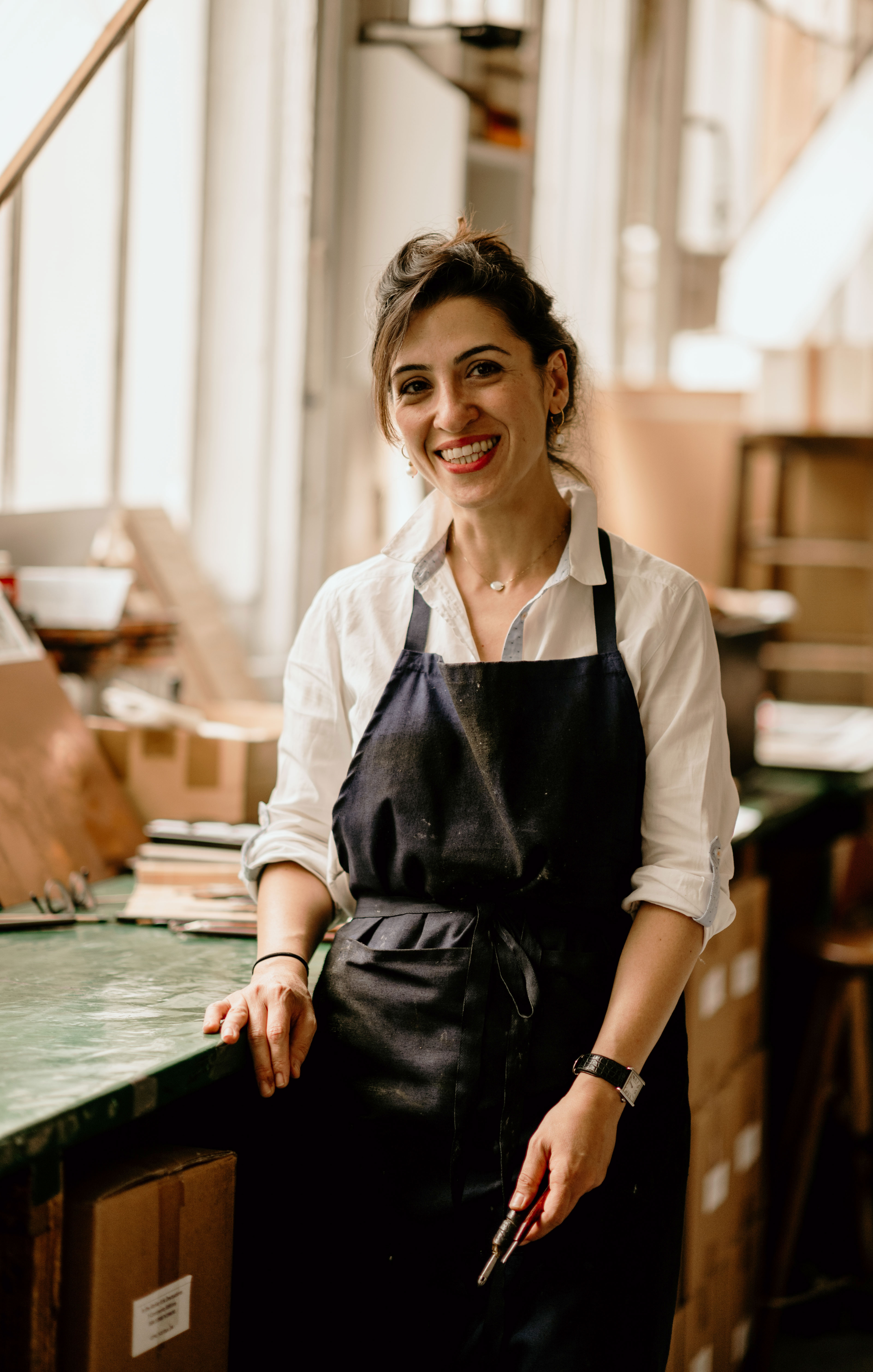 Marjan Seyedin in her studio, holding an engraving tool